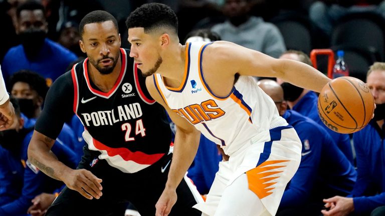 Phoenix Suns guard Devin Booker (1) looks to pass as Portland Portland Trail Blazers forward Norman Powell (24) defends during the first half of a preseason NBA basketball game. (Matt York/AP) 