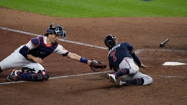 Atlanta Braves' Dansby Swanson scores past Houston Astros catcher Jason Castro on a sacrifice fly during the eighth inning of Game 1 in baseball's World Series between the Houston Astros and the Atlanta Braves Tuesday, Oct. 26, 2021, in Houston. (Eric Gay/AP)