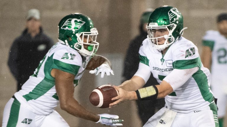 Saskatchewan Roughriders quarterback Cody Fajardo hands off to running back William Powell during second half CFL football action against the Montreal Alouettes in Montreal, Saturday, October 30, 2021. (Graham Hughes/CP)