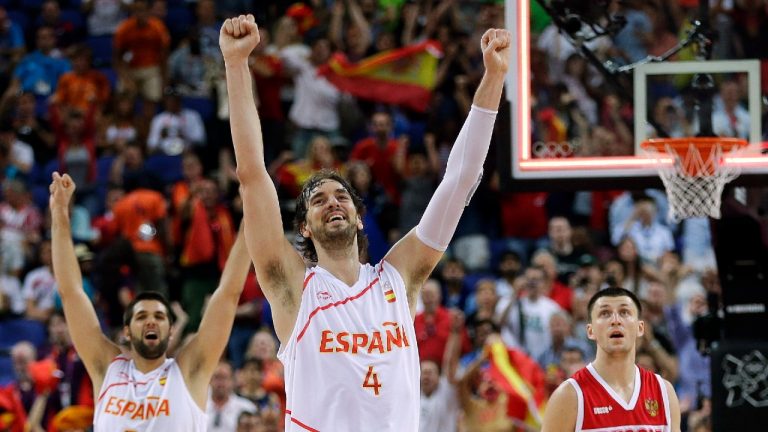 FILE - Spain's Pau Gasol (4) and teammate Felipe Reyes (9) celebrate their win over Russia in a semifinal men's basketball game at the 2012 Summer Olympics in London, in this Friday, Aug. 10, 2012, file photo. Russia's Vitaliy Fridzon is at right. Pau Gasol announced his retirement from basketball on Tuesday, Oct. 5, 2021, ending a career that lasted more than two decades and earned him two NBA titles and a world championship gold with Spain's national team. (Eric Gay/AP)