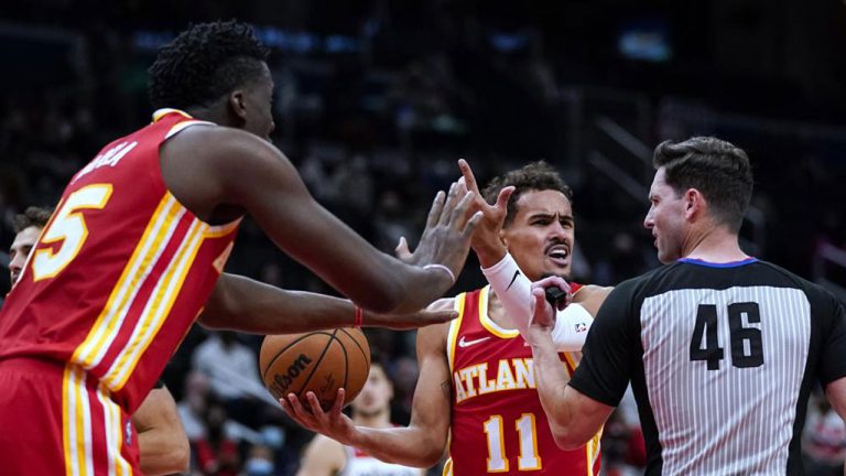 Atlanta Hawks center Clint Capela (15) and guard Trae Young (11) plead their case with referee Ben Taylor (46) during the first half of the team's NBA basketball game. (Alex Brandon/AP)