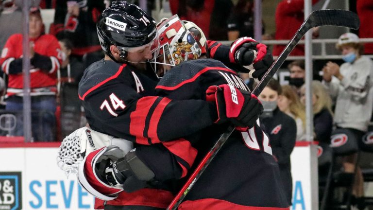 Carolina Hurricanes defenseman Jaccob Slavin (74) hugs goaltender Antti Raanta (32) at the end of an NHL hockey game against the Chicago Blackhawks. (Chris Seward/AP) 