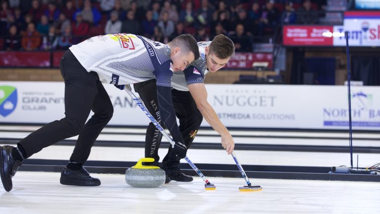 Team Mouat's Hammy McMillan (left) and Grant Hardie (right) sweep a stone during the 2019 Masters in North Bay, Ontario. (Anil Mungal)