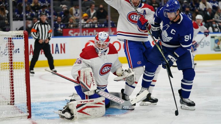 Montreal Canadiens goaltender Sam Montembeault (35) makes a save as Toronto Maple Leafs forward John Tavares (91) and Canadiens defenseman Ben Chiarot (8) battle during the first period of an NHL preseason hockey game, Tuesday, Oct. 5, 2021 in Toronto. (Nathan Denette/The Canadian Press via AP) 
