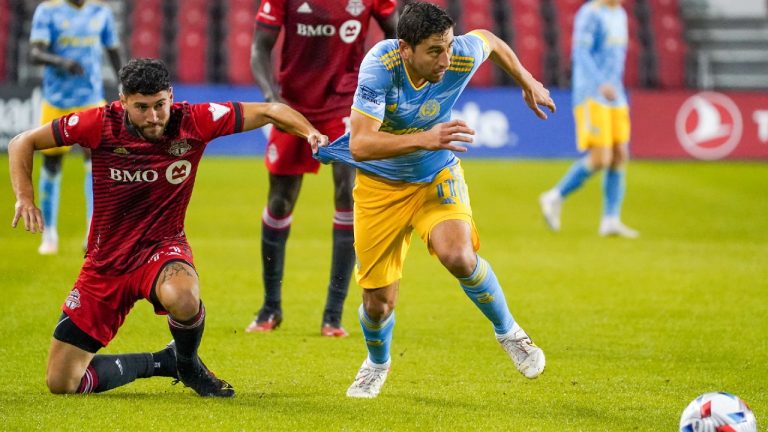 Toronto FC midfielder Jonathan Osorio (21) pulls on the jersey of Philadelphia Union midfielder Alejandro Bedoya (11) during first half MLS action in Toronto on Wednesday, October 27, 2021. (Evan Buhler/CP)