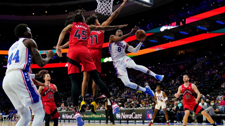 Philadelphia 76ers' Shaquille Harrison (8) goes up for a shot against Toronto Raptors' Justin Champagnie (11) and Dalano Banton (45) during the second half of a preseason NBA basketball game, Thursday, Oct. 7, 2021, in Philadelphia. (Matt Slocum/AP) 