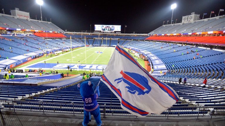 FILE - Buffalo Bills fans leave Bills Stadium as a mascot waves a flag after an NFL divisional round football game against the Baltimore Ravens, Saturday, Jan. 16, 2021, in Orchard Park, N.Y. The Bills won 17-3. Though the Buffalo Bills’ lease on their current stadium doesn’t expire for 21 more months, time is running short on the team reaching a financing agreement with public officials on its proposal to build a new facility (Adrian Kraus/AP).