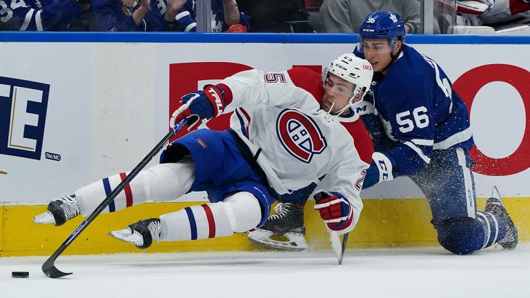 Montreal Canadiens forward Ryan Poehling (25) gets taken out by Toronto Maple Leafs defenseman Kristians Rubins (56) during the second period of an NHL preseason hockey game, Tuesday, Oct. 5, 2021 in Toronto. (Nathan Denette/CP)
