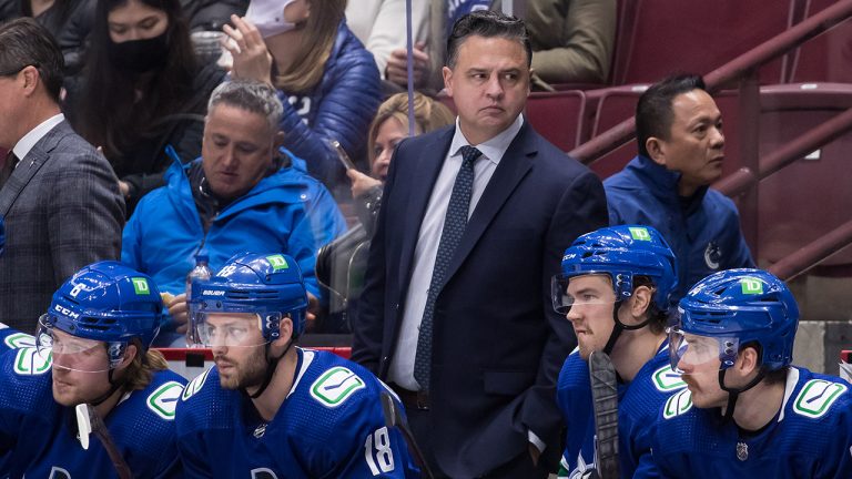 Vancouver Canucks head coach Travis Green, back, stands on the bench behind Brock Boeser, from left to right, Jason Dickinson, Juho Lammikko, of Finland, and Tyler Motte during the second period of an NHL hockey game against the Colorado Avalanche. (Darryl Dyck/THE CANADIAN PRESS)
