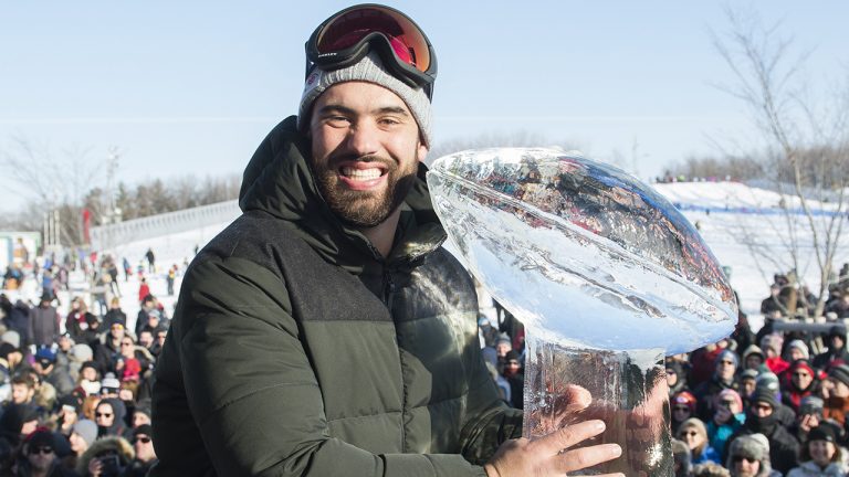 Super Bowl champion  Laurent Duvernay-Tardif poses next to an ice sculpture of the Vince Lombardi trophy during an event to celebrate his win in Montreal. (Graham Hughes/THE CANADIAN PRESS)