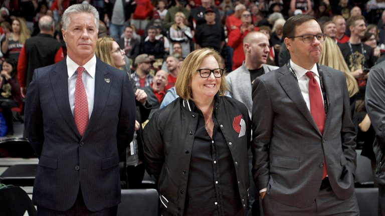 Portland Trail Blazers owner Jody Allen, center, watches warmups with general manager Neil Olshey, left, and president Chris McGowan, right, before the team's NBA basketball game against the Denver Nuggets. (Craig Mitchelldyer/AP)