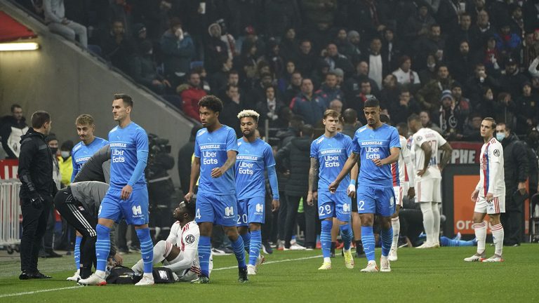 Marseille's players leave the field after Dimitri Payet was injured by an object thrown by a Lyon's supporter during the French League One soccer match between Lyon and Marseille, in Decines, near Lyon, central France. (Laurent Cipriani/AP)
