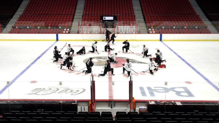 Ottawa Senators players stretch at centre ice at the Canadian Tire Centre. (Justin Tang/CP)