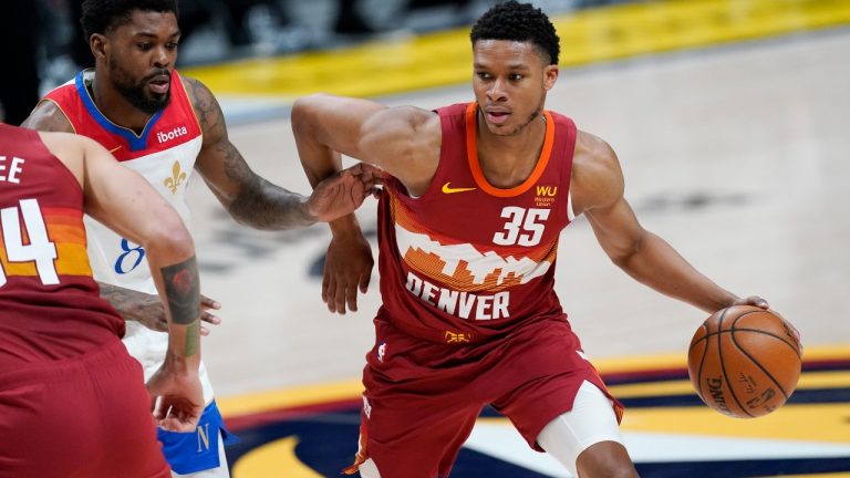 Denver Nuggets guard PJ Dozier, right, drives past New Orleans Pelicans forward Naji Marshall in the first half of an NBA basketball game Wednesday, April 28, 2021, in Denver. (David Zalubowski/AP)
