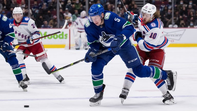 New York Rangers' Artemi Panarin (10), of Russia, checks Vancouver Canucks' Tucker Poolman (5) during the first period of an NHL hockey game in Vancouver, on Tuesday, November 2, 2021. (Darryl Dyck/CP)