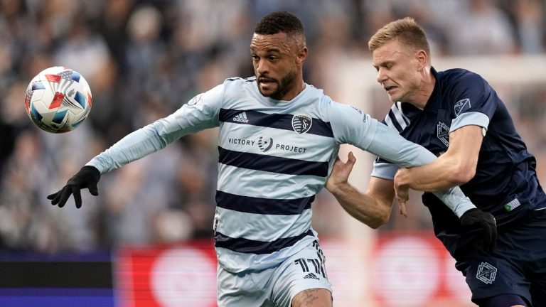 Sporting Kansas City forward Khiry Shelton (11) and Vancouver Whitecaps midfielder Andy Rose, right, chase the ball during the first half of an MLS soccer match, Saturday, Nov. 20, 2021, in Kansas City, Kan (Charlie Riedel/AP).