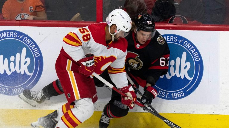 Calgary Flames defenceman Oliver Kylington (58) checks Ottawa Senators right wing Tyler Ennis off the puck during first period NHL action, in Ottawa, Sunday, Nov. 14, 2021. (Adrian Wyld/THE CANADIAN PRESS) 

