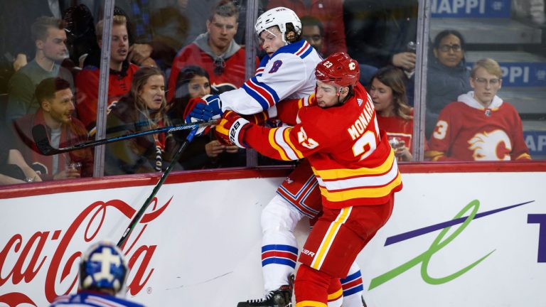 New York Rangers' Jacob Trouba, left, is checked by Calgary Flames' Sean Monahan during third period NHL hockey action. (Jeff McIntosh/CP)