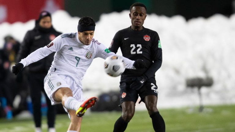 Canada's Richie Laryea (22) and Mexico's Edson Omar Alvarez Velazquez (4) via for the ball during World Cup Qualifiers in Edmonton, Tuesday, Nov. 16, 2021. (Jason Franson/THE CANADIAN PRESS) 
