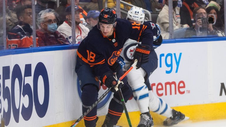 Winnipeg Jets' Logan Stanley (64) and Edmonton Oilers' Zach Hyman (18) battle for the puck during second period NHL action. (Jason Franson/CP)
