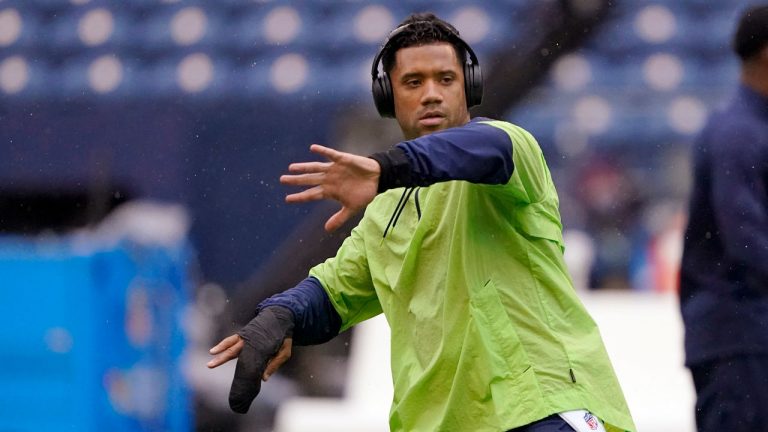 Seattle Seahawks injured quarterback Russell Wilson goes through a throwing motion on the field before an NFL football game against the New Orleans Saints. (Ted S. Warren/AP) 