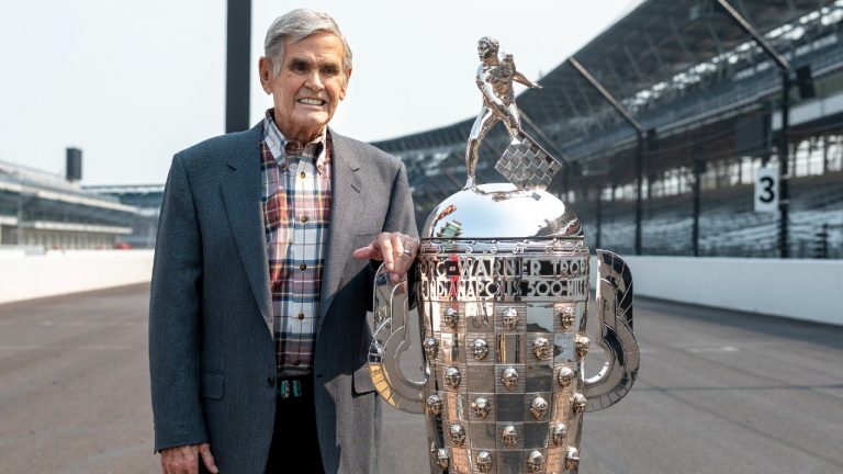 Four-time winner of the Indianapolis 500, Al Unser, poses with the Borg-Warner Trophy at the Indianapolis Motor Speedway in Indianapolis, Tuesday, July 20, 2021. (Doug McSchooler/AP)