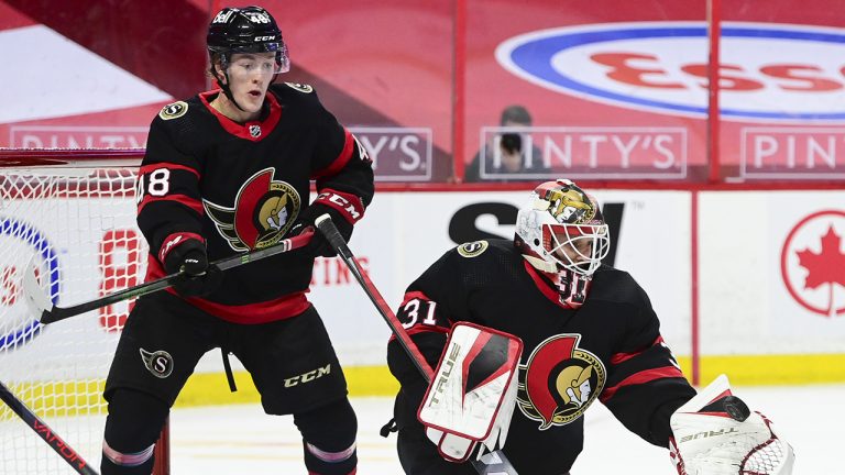 Ottawa Senators goaltender Anton Forsberg makes a save as Jacob Bernard-Docker looks on. (Sean Kilpatrick/CP)