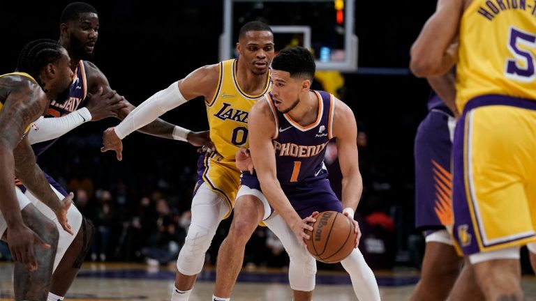 Phoenix Suns' Devin Booker, center right, is pressured by Los Angeles Lakers' Russell Westbrook during first half of an NBA basketball game Tuesday, Dec. 21, 2021, in Los Angeles. (Jae C. Hong/AP)