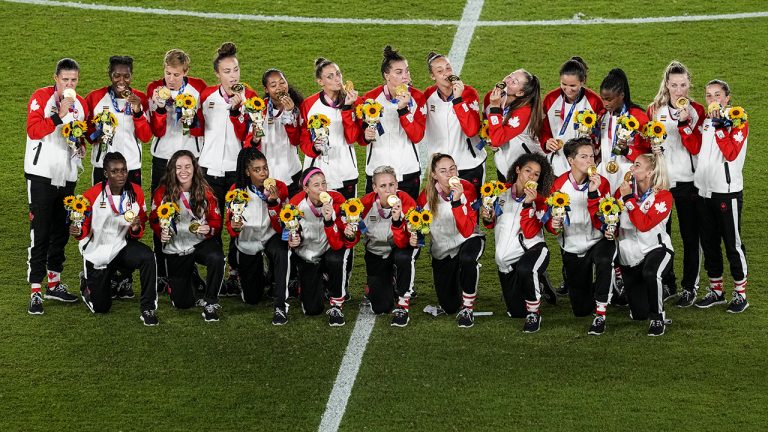 Canada pose after winning the women's final gold medal at the 2020 Summer Olympics. (Kiichiro Sato/AP)