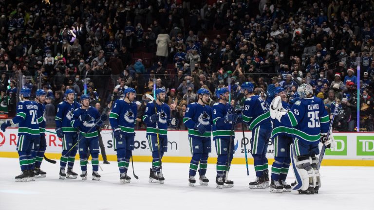 Vancouver Canucks' Brock Boeser, second right, and goalie Thatcher Demko, right, celebrate after Vancouver defeated the Los Angeles Kings during an NHL hockey game in Vancouver, B.C., Monday, Dec. 6, 2021. (Darryl Dyck/CP) 