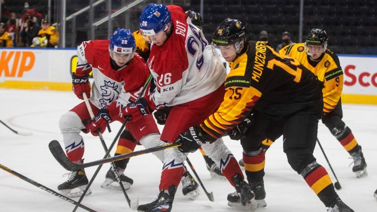 Czech Republic's Michal Gut (26) and Tomas Urban (20) battle for the puck with battles for the puck with Germany's Luca MŸnzenberger (15) during first period IIHF World Junior Hockey Championship action in Edmonton on Monday, December 27, 2021. (Jason Franson/CP)