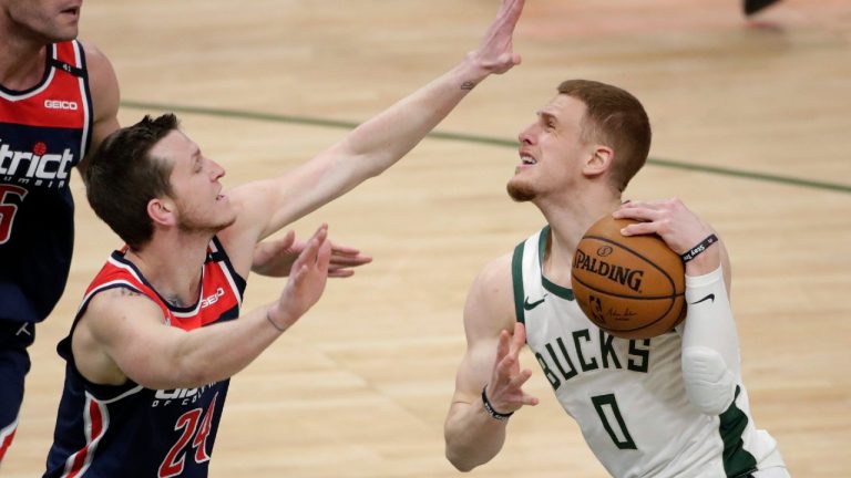 Milwaukee Bucks' Donte DiVincenzo (0) drives on Washington Wizards' Garrison Mathews during the second half of an NBA basketball game Wednesday, May 5, 2021, in Milwaukee. DiVincenzo was called for an offensive foul (Aaron Gash/AP).