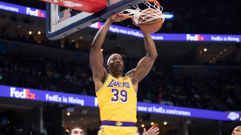 Los Angeles Lakers center Dwight Howard dunks over Memphis Grizzlies' Steven Adams, left, during the second half of an NBA basketball game Thursday, Dec. 9, 2021, in Memphis, Tenn (Nikki Boertman/AP).