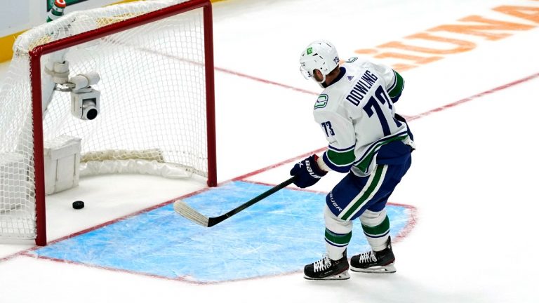 Vancouver Canucks' Justin Dowling scores an empty-net goal against the Seattle Kraken during the third period of an NHL hockey game Saturday, Oct. 23, 2021, in Seattle. The Canucks won 4-2 (Elaine Thompson/AP).