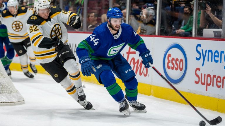 Vancouver Canucks defenceman Kyle Burroughs (44) fights for control of the puck with Boston Bruins centre Oskar Steen (62) during first period NHL action in Vancouver, Wednesday, December 8, 2021. (Jonathan Hayward/CP)