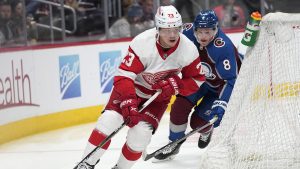 Detroit Red Wings right wing Lucas Raymond, front, wraps around the net for a shot as Colorado Avalanche defenceman Cale Makar pursues in the second period of an NHL hockey game. (David Zalubowski/AP)