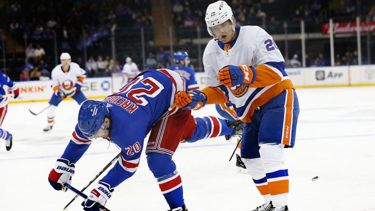 New York Rangers left wing Chris Kreider (20) and New York Islanders left wing Kieffer Bellows (20) collide while playing the puck. (Noah K. Murray/AP)