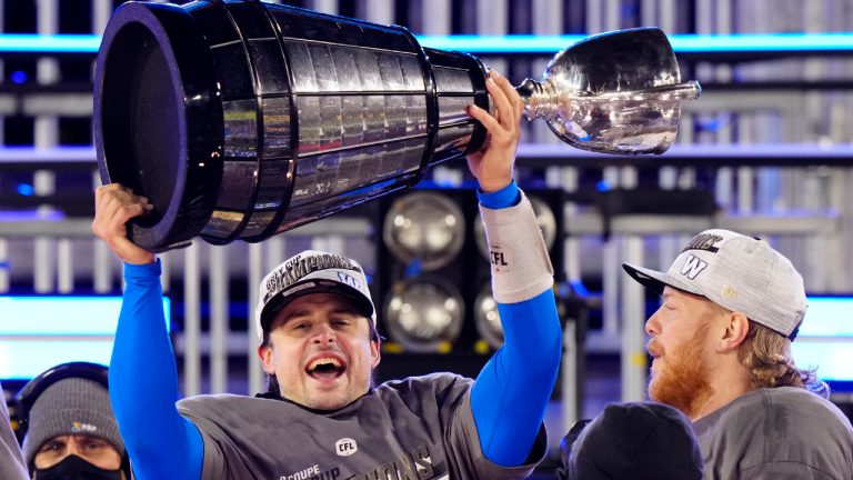 Winnipeg Blue Bombers quarterback Zach Collaros (8) hoists the Grey Cup as he celebrates defeating the Hamilton Tiger-Cats in the 108th CFL Grey Cup in Hamilton, Ont., on Sunday, December 12, 2021. (Frank Gunn/CP)
