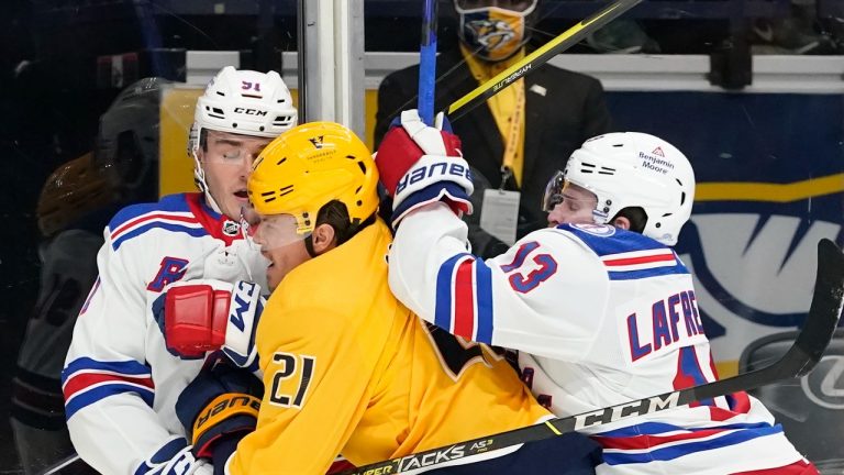 Nashville Predators center Nick Cousins (21) gets caught between New York Rangers' Sammy Blais (91) and Alexis Lafreniere (13) in the first period of an NHL hockey game Thursday, Oct. 21, 2021, in Nashville, Tenn. (Mark Humphrey/AP Photo) 
