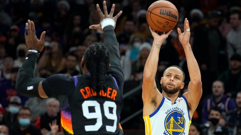 Golden State Warriors guard Stephen Curry shoots over Phoenix Suns forward Jae Crowder (99) during the first half of an NBA basketball game Saturday, Dec. 25, 2021, in Phoenix. (Rick Scuteri/AP)