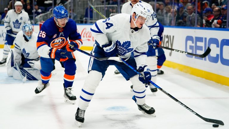 New York Islanders' Oliver Wahlstrom (26) fights for control of the puck with Toronto Maple Leafs' David Kampf (64) during the second period of an NHL hockey game Sunday, Nov. 21, 2021, in Elmont, N.Y. (Frank Franklin II/AP)