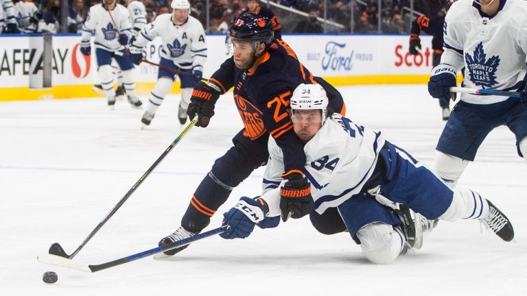 Toronto Maple Leafs' Auston Matthews (34) and Edmonton Oilers' Darnell Nurse (25) battle for the puck during first period NHL action in Edmonton on Tuesday, December 14, 2021. (Jason Franson/CP)