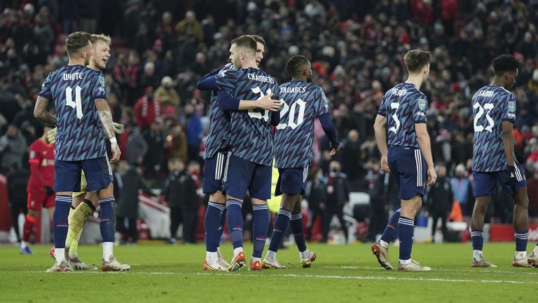 Arsenal players hug after the EFL Cup semifinal, first leg soccer match between Liverpool and Arsenal. (Jon Super/AP)