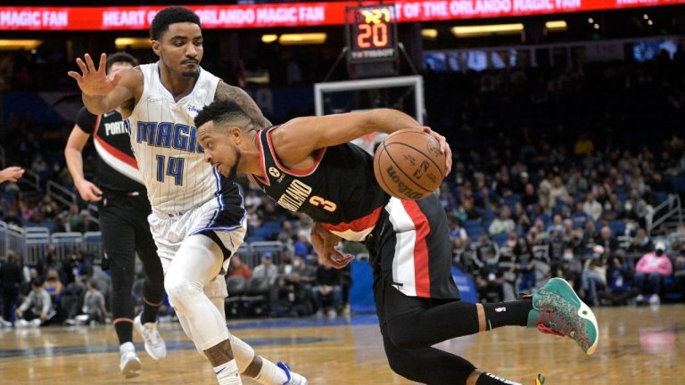 Portland Trail Blazers guard CJ McCollum (3) drives to the basket in front of Orlando Magic guard Gary Harris (14) during the first half of an NBA basketball game, Monday, Jan. 17, 2022, in Orlando, Fla. (Phelan M. Ebenhack/AP)