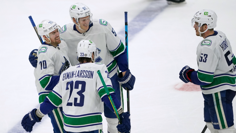 Vancouver Canucks left wing Tanner Pearson, left, is greeted by teammates after he scored an empty-net goal during the third period against the Seattle Kraken, Saturday, Jan. 1, 2022, in Seattle. (AP/file) 
