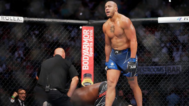 Ciryl Gane, right, walks away as referee Dan Miragliotta, left, looks over Derrick Lewis, after Gane's win by technical knockout in the third round of their interim heavyweight mixed martial arts title bout at UFC 265 on Saturday, Aug. 7, 2021, in Houston. (Michael Wyke/AP)