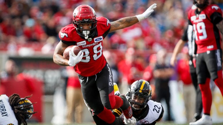 Hamilton Tiger-Cats' Justin Tuggle, right, brings down Calgary Stampeders' Colton Hunchak during second half CFL football action in Calgary, Saturday, Sept. 14, 2019.(Jeff McIntosh/CP) 
