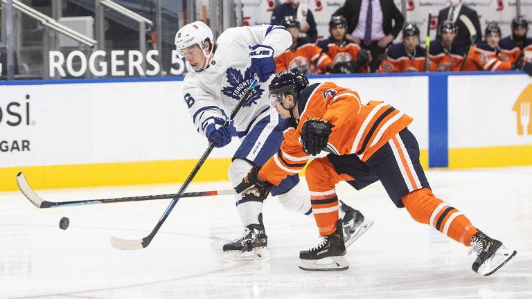 Edmonton Oilers' Kris Russell (4) chases Toronto Maple Leafs' Mitchell Marner (16) as he gets the shot off during first period NHL action. (Jason Franson/CP)