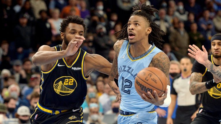 Memphis Grizzlies guard Ja Morant (12) handles the ball ahead of Golden State Warriors forward Andrew Wiggins (22) in the second half of an NBA basketball game Tuesday, Jan. 11, 2022, in Memphis, Tenn. (Brandon Dill/AP)