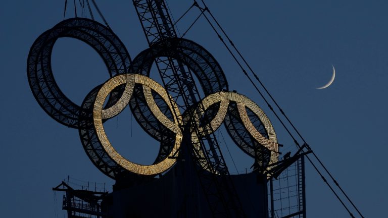 Pairs skaters Kirsten Moore-Towers, of St. Catharines, Ont., and Michael Marinaro, of Sarnia, Ont., embrace after changing into their Team Canada shirts for a photo during an announcement that they will represent Canada at the 2022 Beijing Olympics, in Ottawa, on Sunday, Jan. 9, 2022. (Justin Tang/CP) 